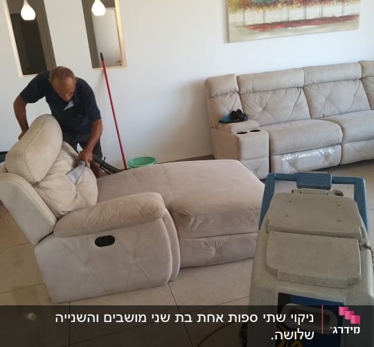 אדם מנקה ספה עם שואב אבק מקצועי